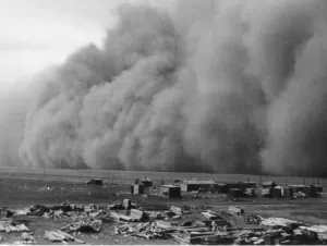 A dust storm rolling over a prairie settlement in the 1930s