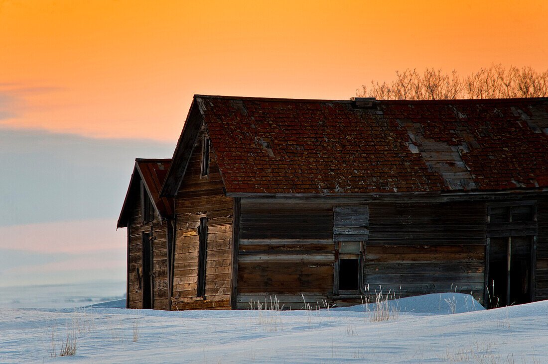 An old barn on the Alberta prairie at winter sunset