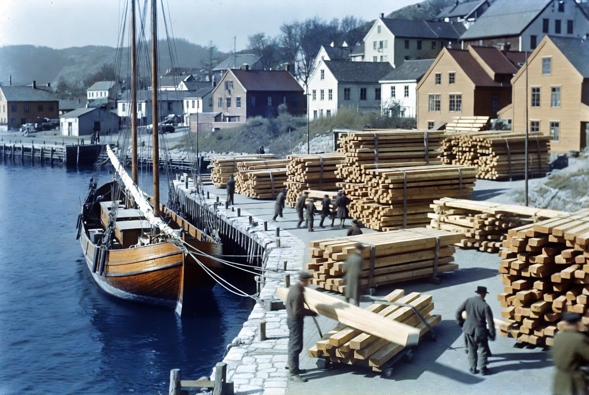 A Norwegian timber-and-sailing harbour town with a barque at a stone quay, 1880s