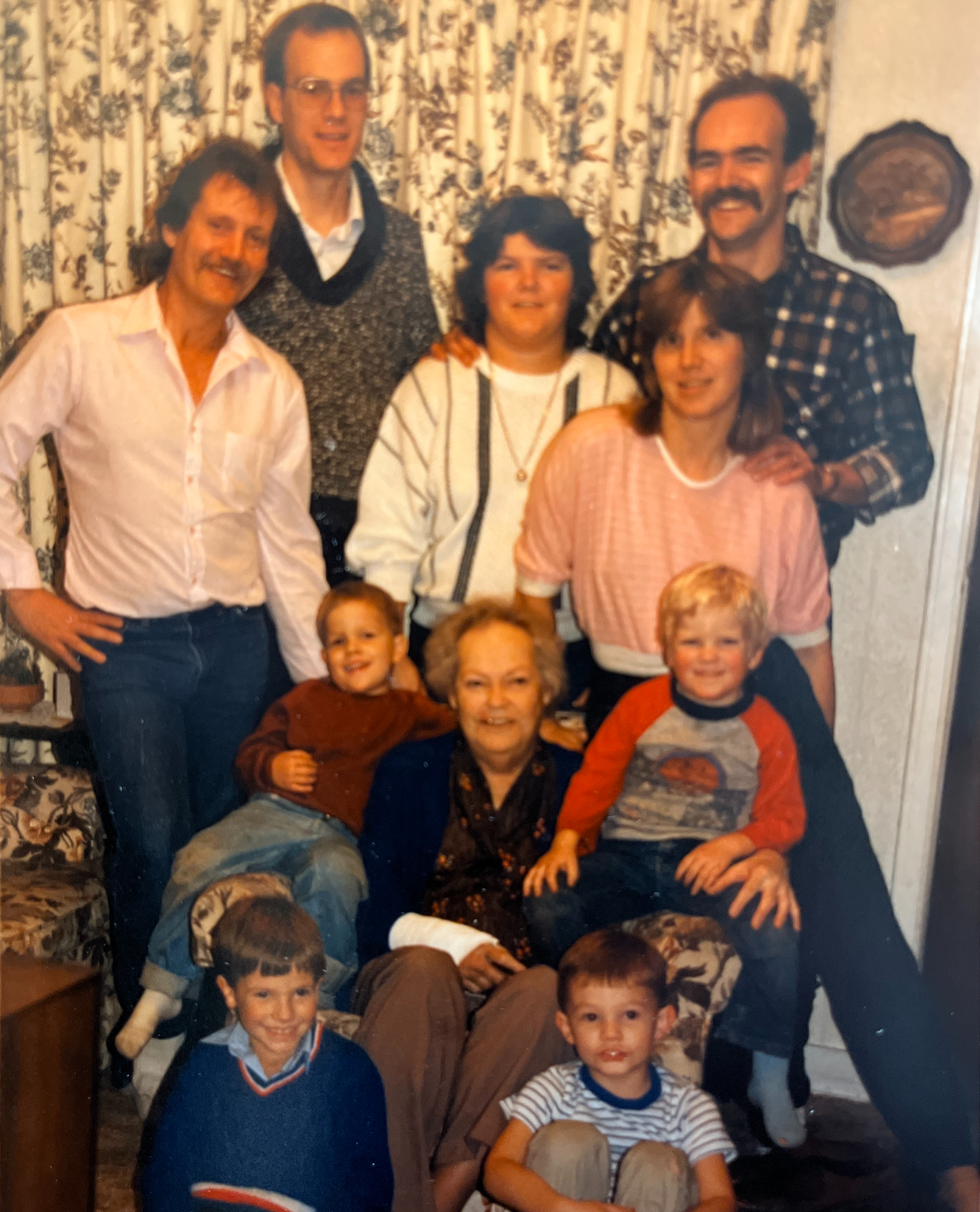 A family photo of Ganny Docherty, her 2 sons Rick and Davey, her daughter Maryanne and Daughter in law Laura, Son in Law Martin. Jonathan, Chris, Thomas, and Levi are the grandchildren sitting with the family in the photo