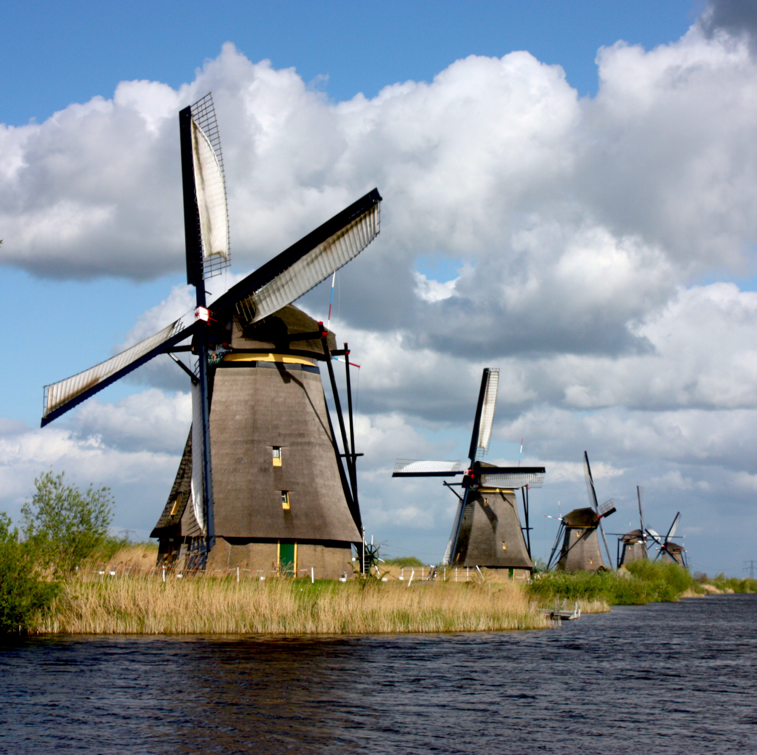 A row of Dutch polder windmills along a canal