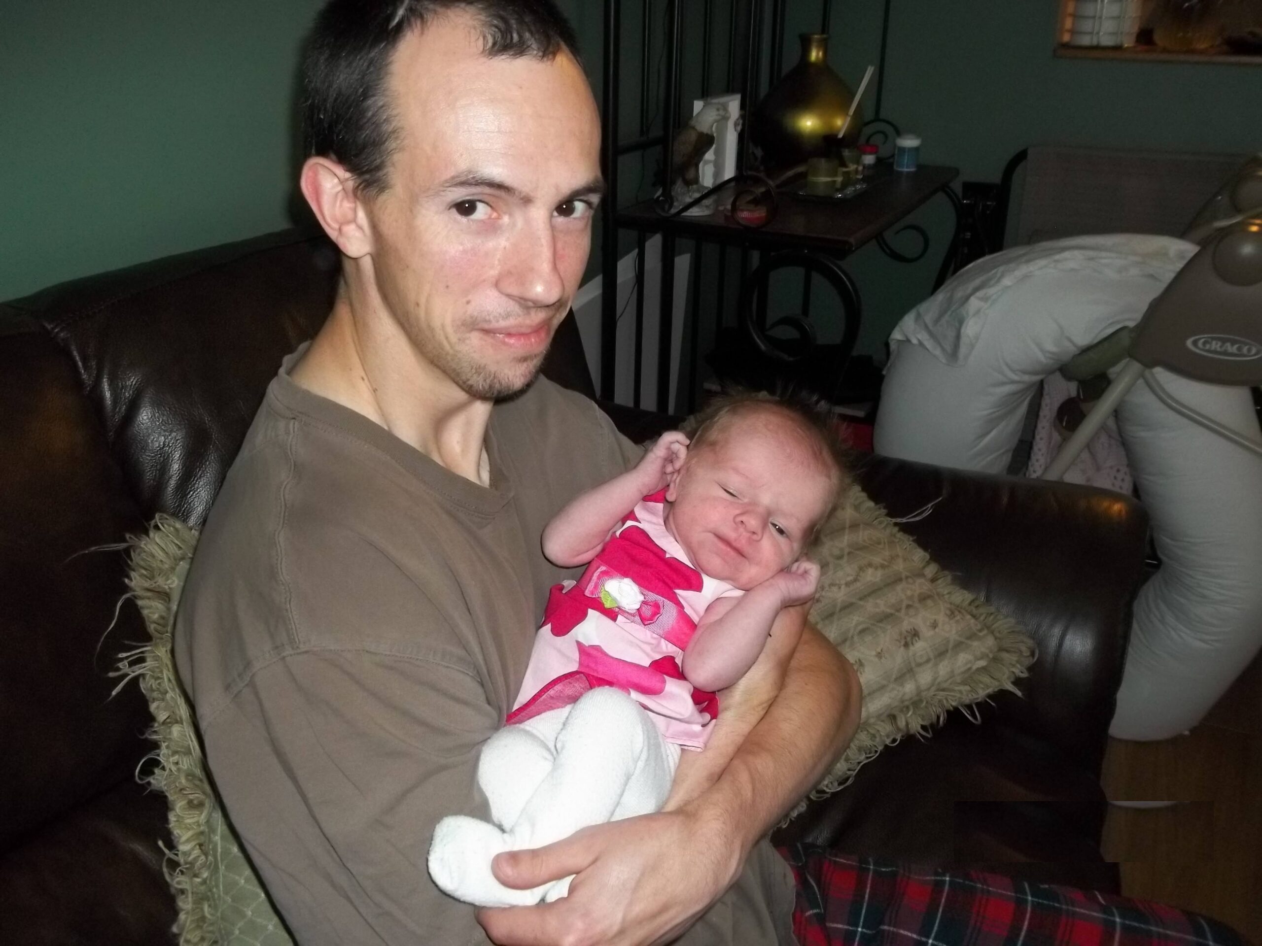 Thomas Cheesman holding his newborn
