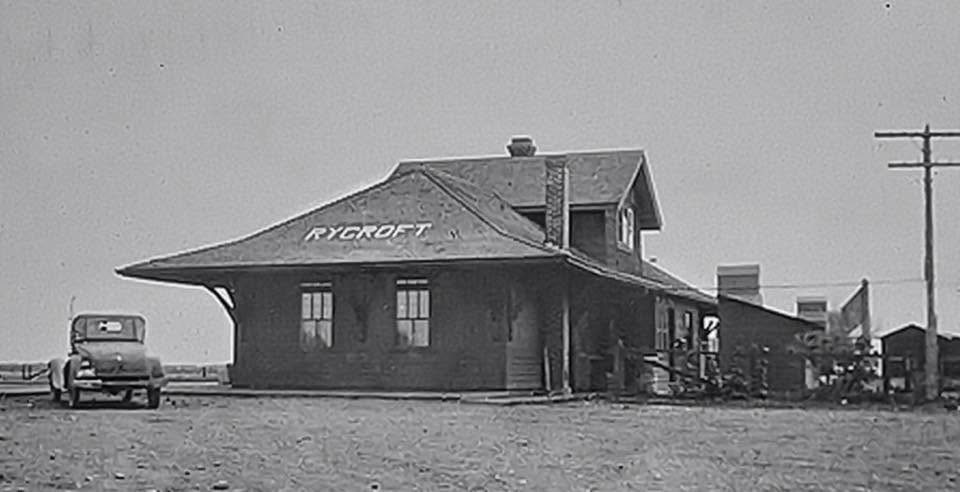 An early black-and-white photograph of the wooden Rycroft railway station on the prairie